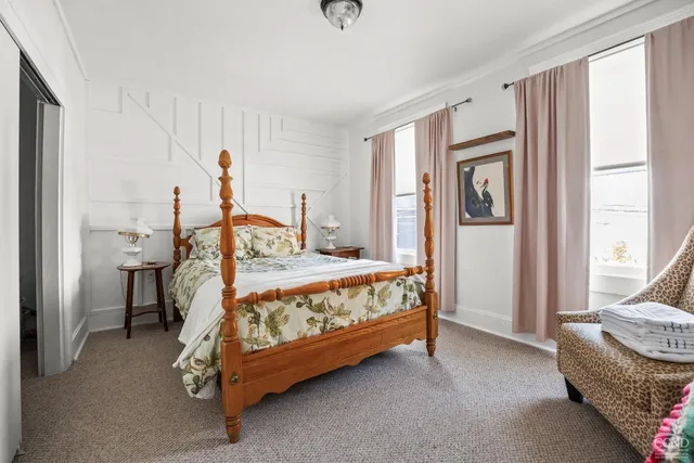 a bedroom with a bed and windows