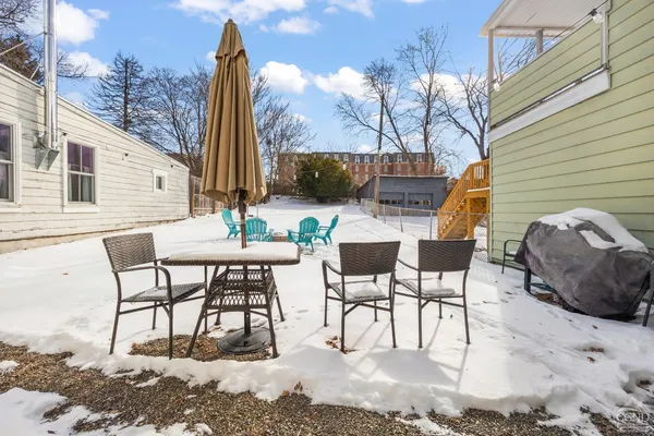 a view of a patio with table and chairs and floor to ceiling window
