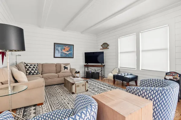 a living room with furniture a flat screen tv and a large window