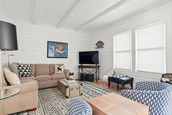 a living room with furniture a flat screen tv and a window