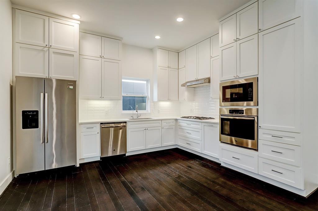 a kitchen with granite countertop white cabinets and stainless steel appliances