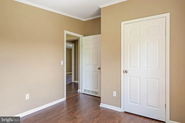 an empty room with wooden floor and closet