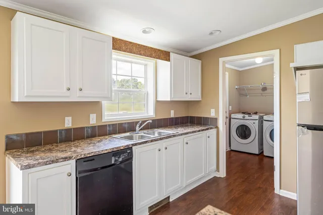 a kitchen with stainless steel appliances granite countertop a sink and cabinets with wooden floor