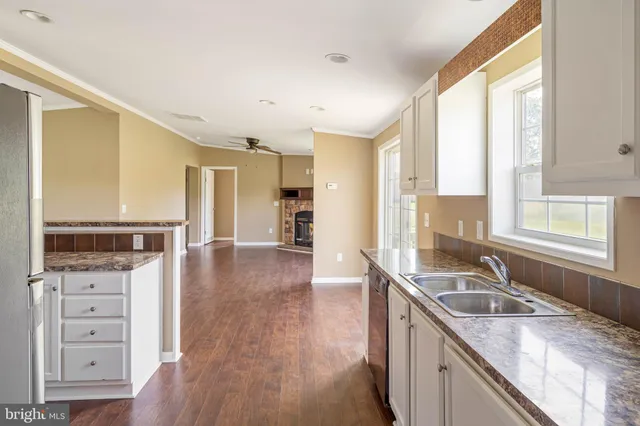 a kitchen with granite countertop a sink and a refrigerator