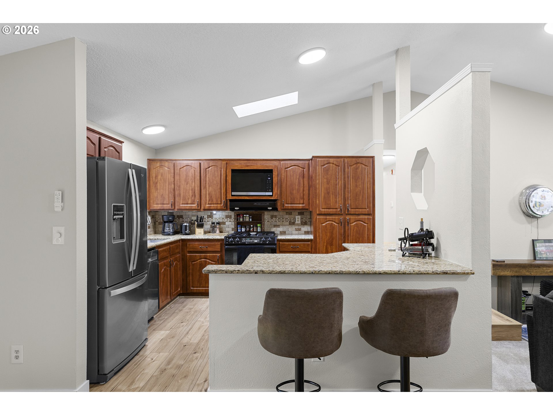 1472 Southwest 14th Street Gresham, OR 97080 - Photo 10 of 40 a kitchen with stainless steel appliances granite countertop a stove a sink dishwasher a refrigerator and a dining table with wooden cabinet