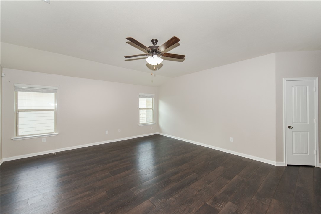 1007 Plateau Trail Georgetown, TX 78626 - Photo 6 of 32 an empty room with wooden floor fan and windows