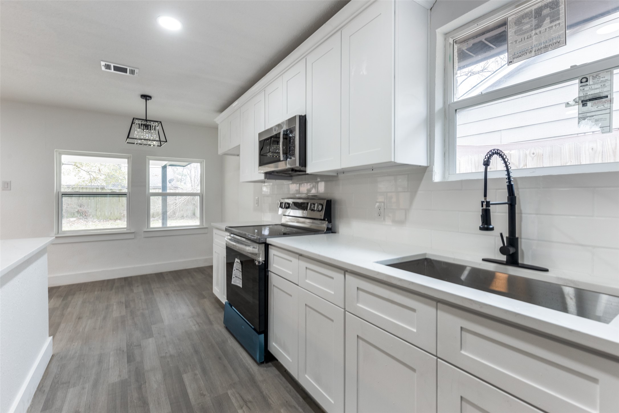 23115 Lestergate Drive Spring, TX 77373 - Photo 12 of 25 a kitchen with stainless steel appliances granite countertop a sink a stove and a wooden floors