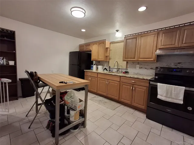 a kitchen with kitchen island granite countertop a sink cabinets and stainless steel appliances