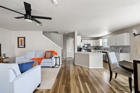 a living room with furniture and a view of kitchen