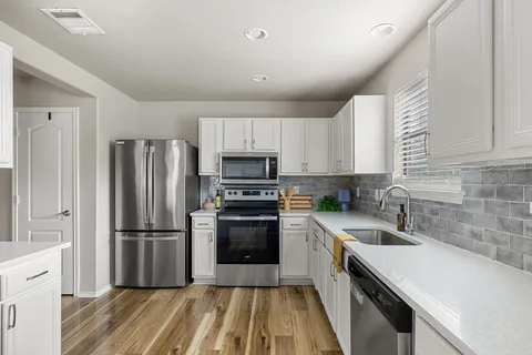a kitchen with wooden cabinets and stainless steel appliances