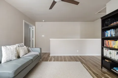 a view of a hallway with wooden floor and staircase