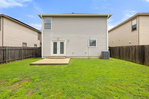 a view of a house with a yard and wooden fence