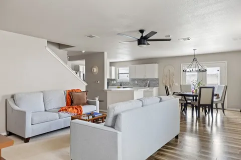 a living room with furniture and a wooden floor