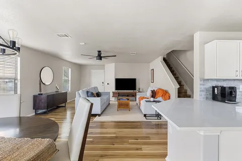 a kitchen with white cabinets and chairs