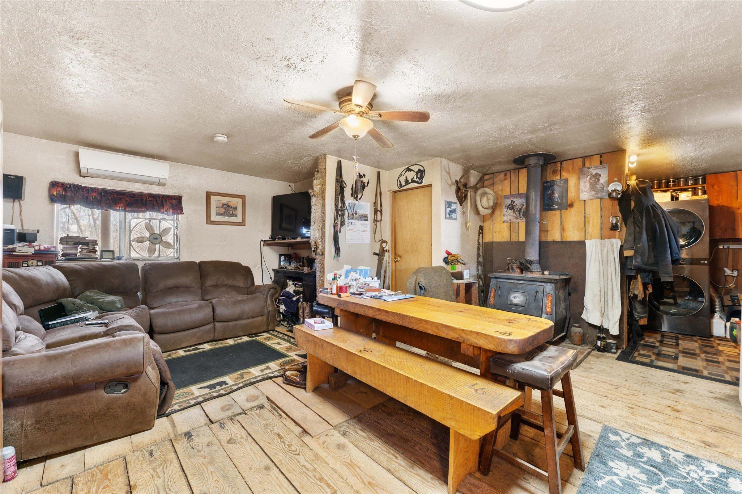 11555 Liberty Road Sweet, ID 83670 - Photo 29 of 49 Dining room featuring ceiling fan, light wood finished floors, a textured ceiling, and a wood stove