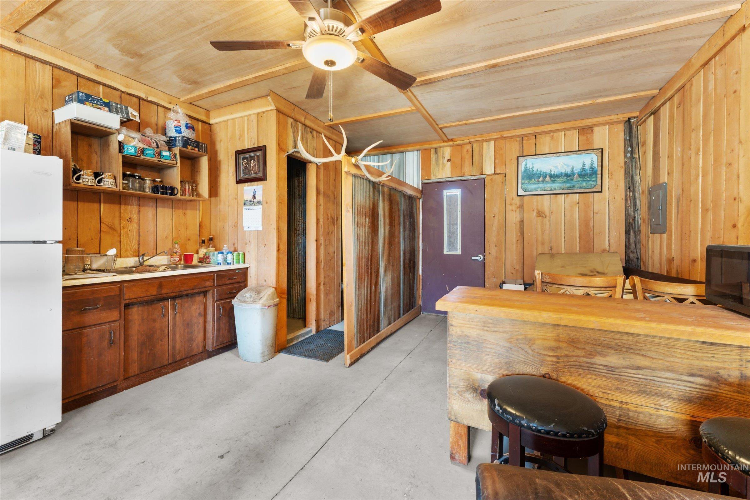 11555 Liberty Road Sweet, ID 83670 - Photo 7 of 49 Kitchen with concrete flooring, freestanding refrigerator, light countertops, wood walls, and open shelves