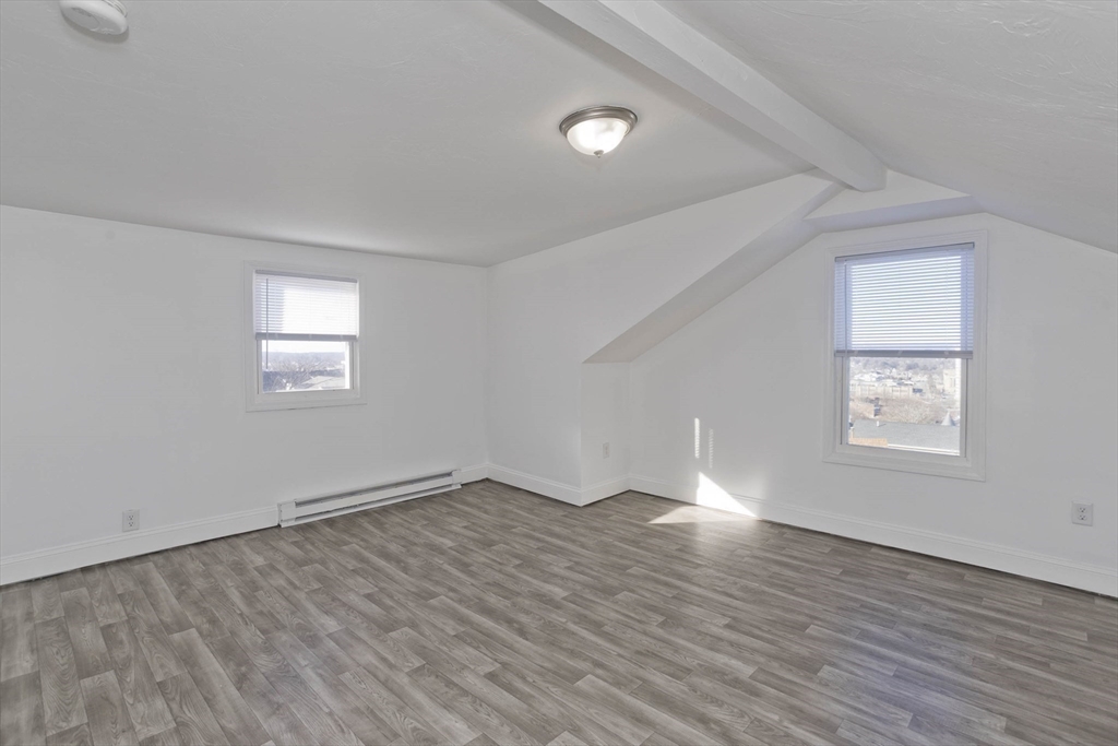 107 Eastern Avenue Worcester, MA 01605 - Photo 12 of 38 an empty room with wooden floor and windows