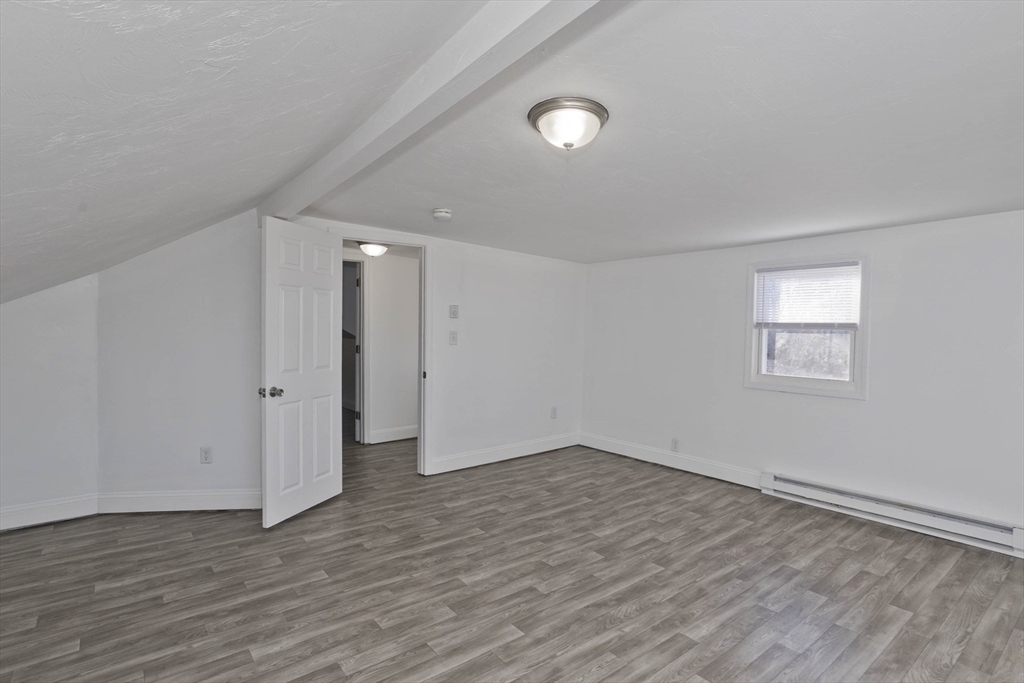 107 Eastern Avenue Worcester, MA 01605 - Photo 15 of 38 a view of an empty room with wooden floor and a window
