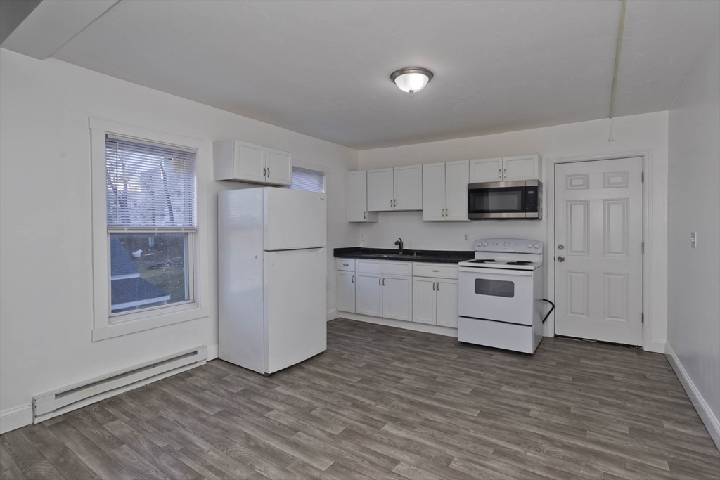 107 Eastern Avenue Worcester, MA 01605 - Photo 3 of 38 a kitchen with white cabinets and white appliances