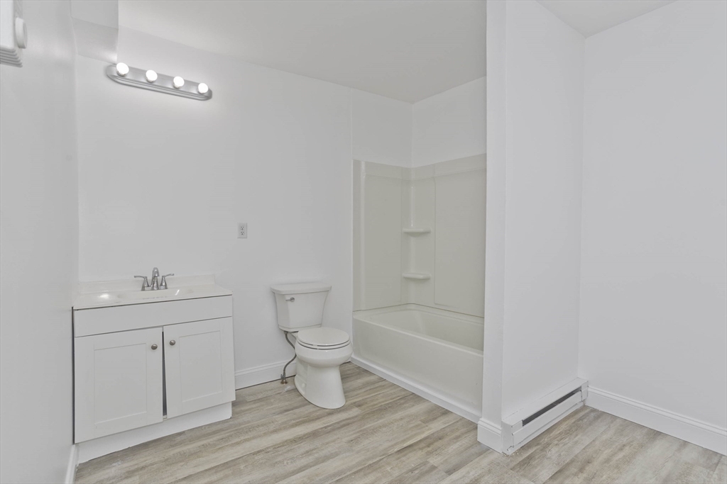 107 Eastern Avenue Worcester, MA 01605 - Photo 7 of 38 a bathroom with a toilet a sink and mirror
