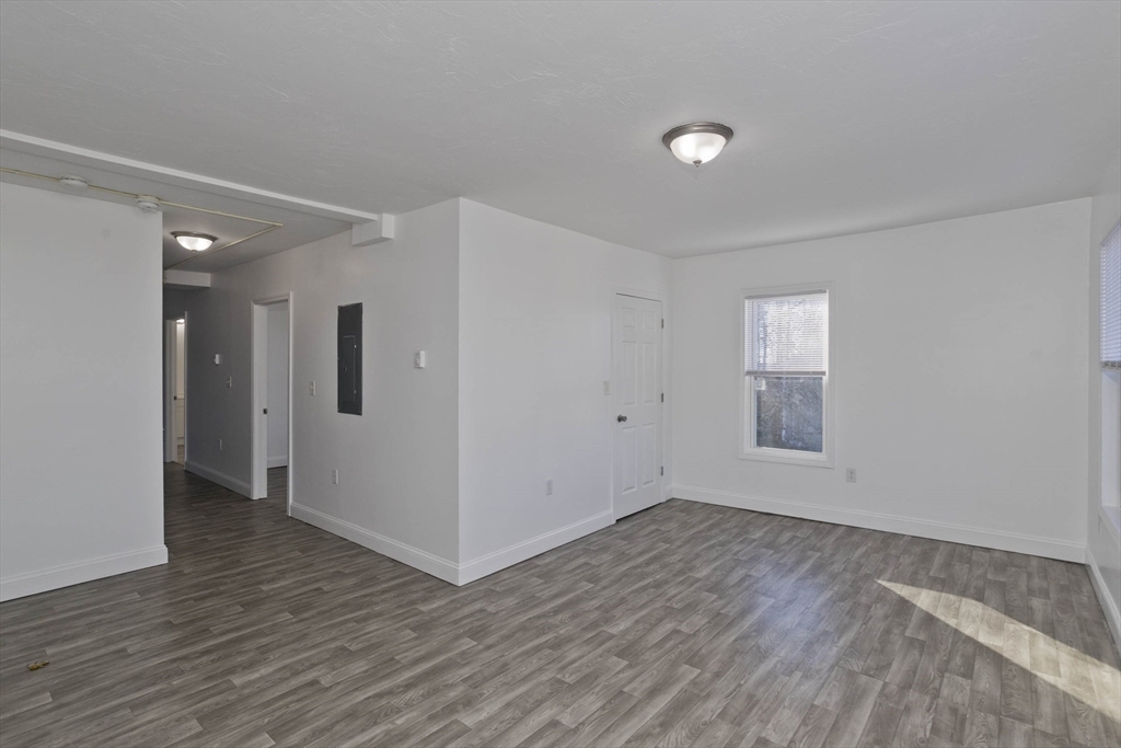 107 Eastern Avenue Worcester, MA 01605 - Photo 10 of 38 an empty room with wooden floor and windows