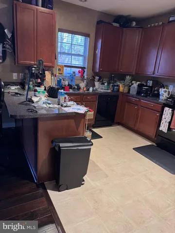 a kitchen with kitchen island granite countertop a sink wooden cabinets and a counter top space