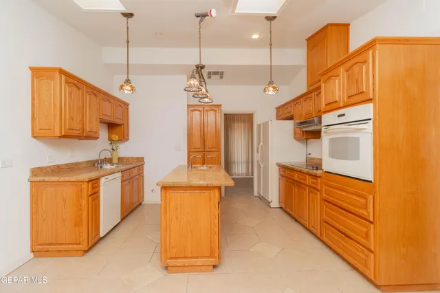 a kitchen with stainless steel appliances granite countertop a sink a stove and oven