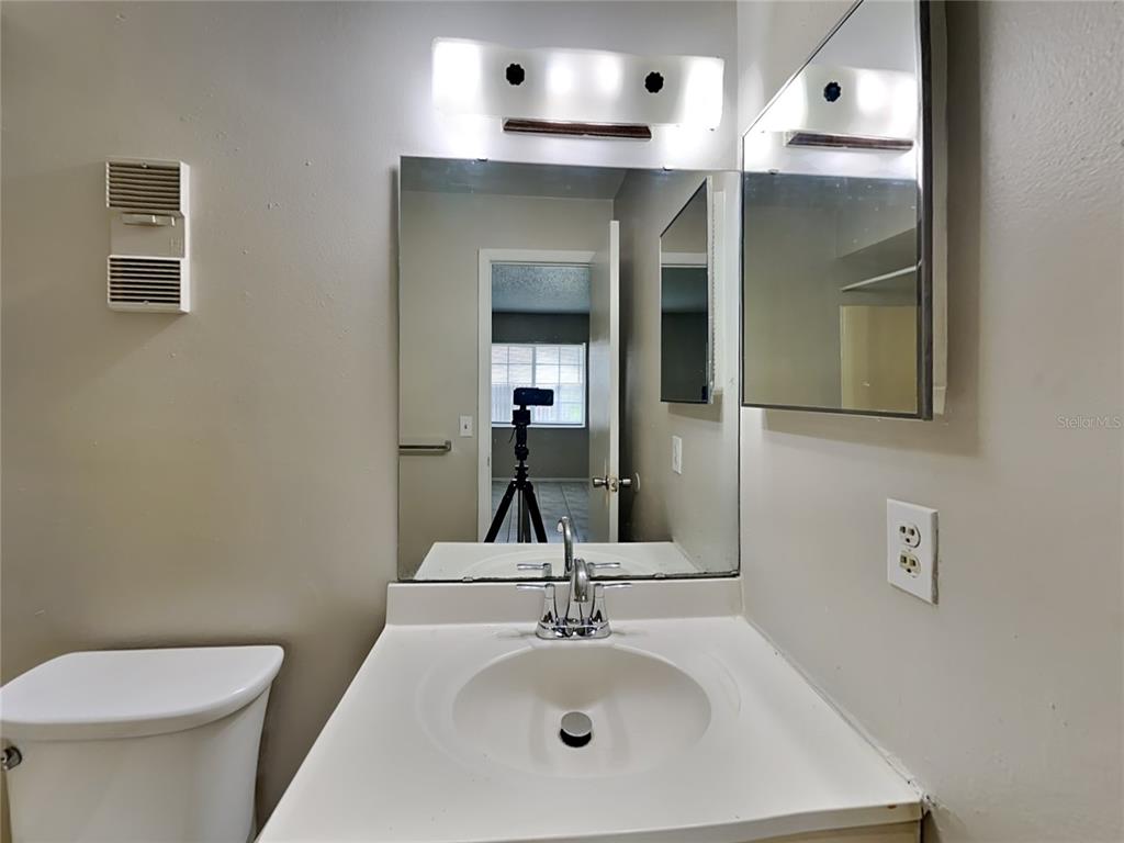 1921 Truman Road Orlando, FL 32807 - Photo 13 of 19 a bathroom with a sink a toilet and mirror