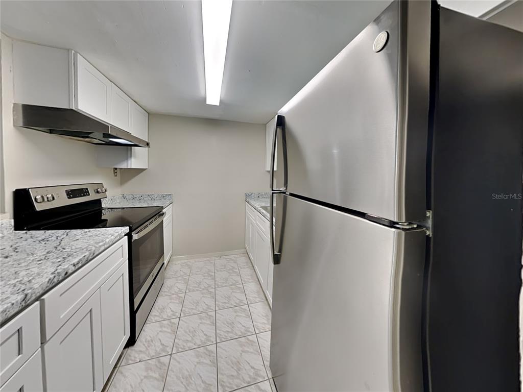 1921 Truman Road Orlando, FL 32807 - Photo 2 of 19 a kitchen with a refrigerator and a stove top oven