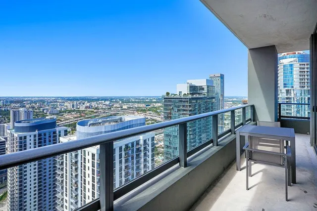 a view of city from a balcony with furniture
