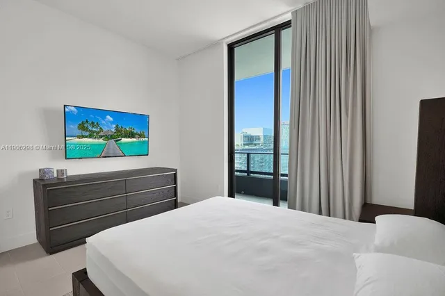 a bedroom with a bed and a flat screen tv