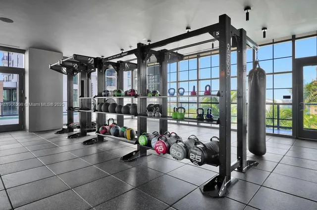 a room with lots of gym equipment and furniture