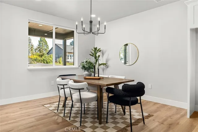 a view of a dining room with furniture a chandelier and wooden floor