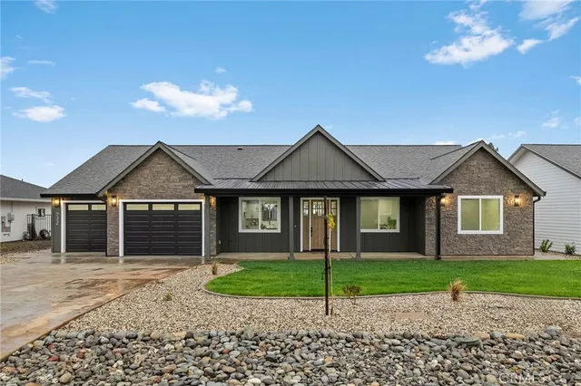 a front view of a house with a garden and yard
