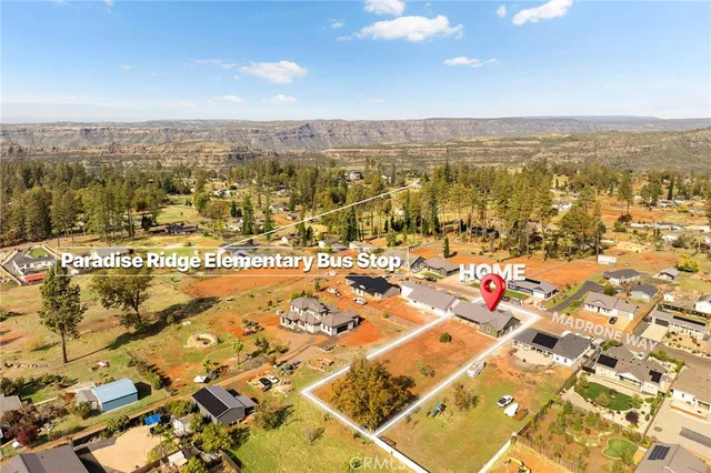 a view of residential houses with yard and trees
