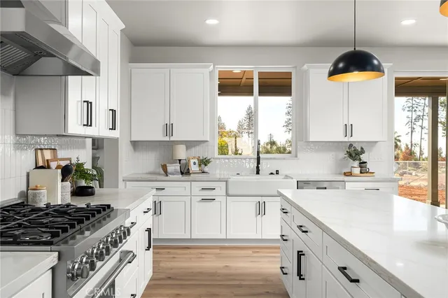 a kitchen with stainless steel appliances a sink a stove and a window