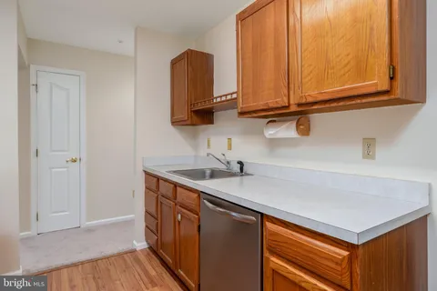 a kitchen with stainless steel appliances granite countertop a sink and dishwasher with wooden floor