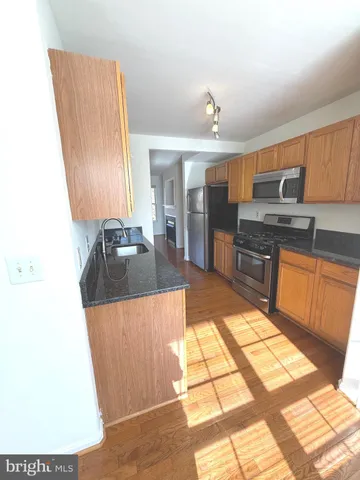 a kitchen with stainless steel appliances granite countertop a sink stove and cabinets