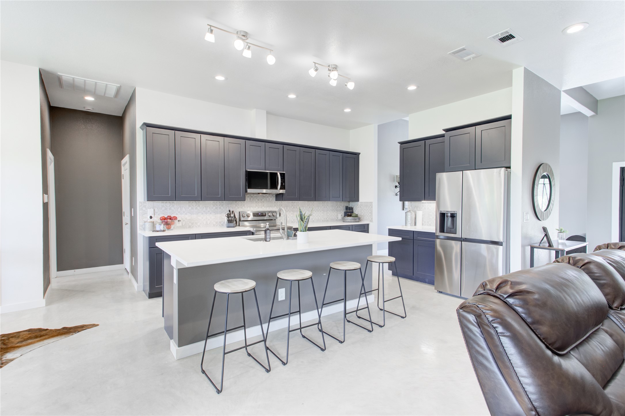 1215 Ridge Harbor Drive Spicewood, TX 78669 - Photo 39 of 39 a kitchen with stainless steel appliances kitchen island granite countertop a refrigerator a stove a sink a dining table and chairs