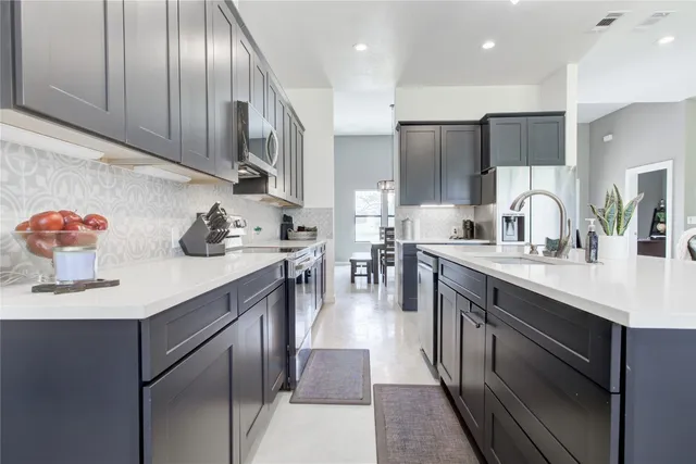 a kitchen with a sink a stove and chairs