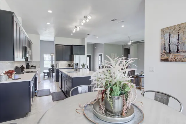 a kitchen with stainless steel appliances granite countertop a sink a stove and a refrigerator