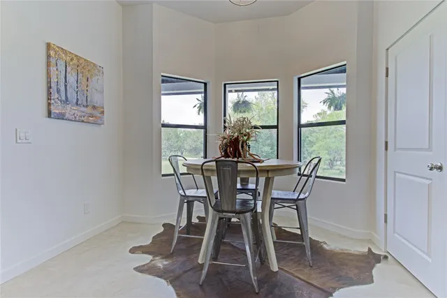 a living room with furniture a potted plant and a kitchen view