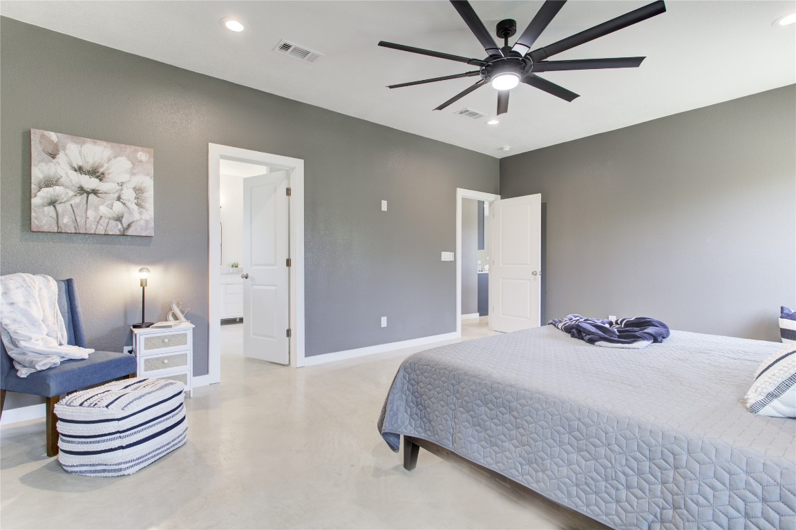 1215 Ridge Harbor Drive Spicewood, TX 78669 - Photo 18 of 39 a bedroom with a bed and a chandelier