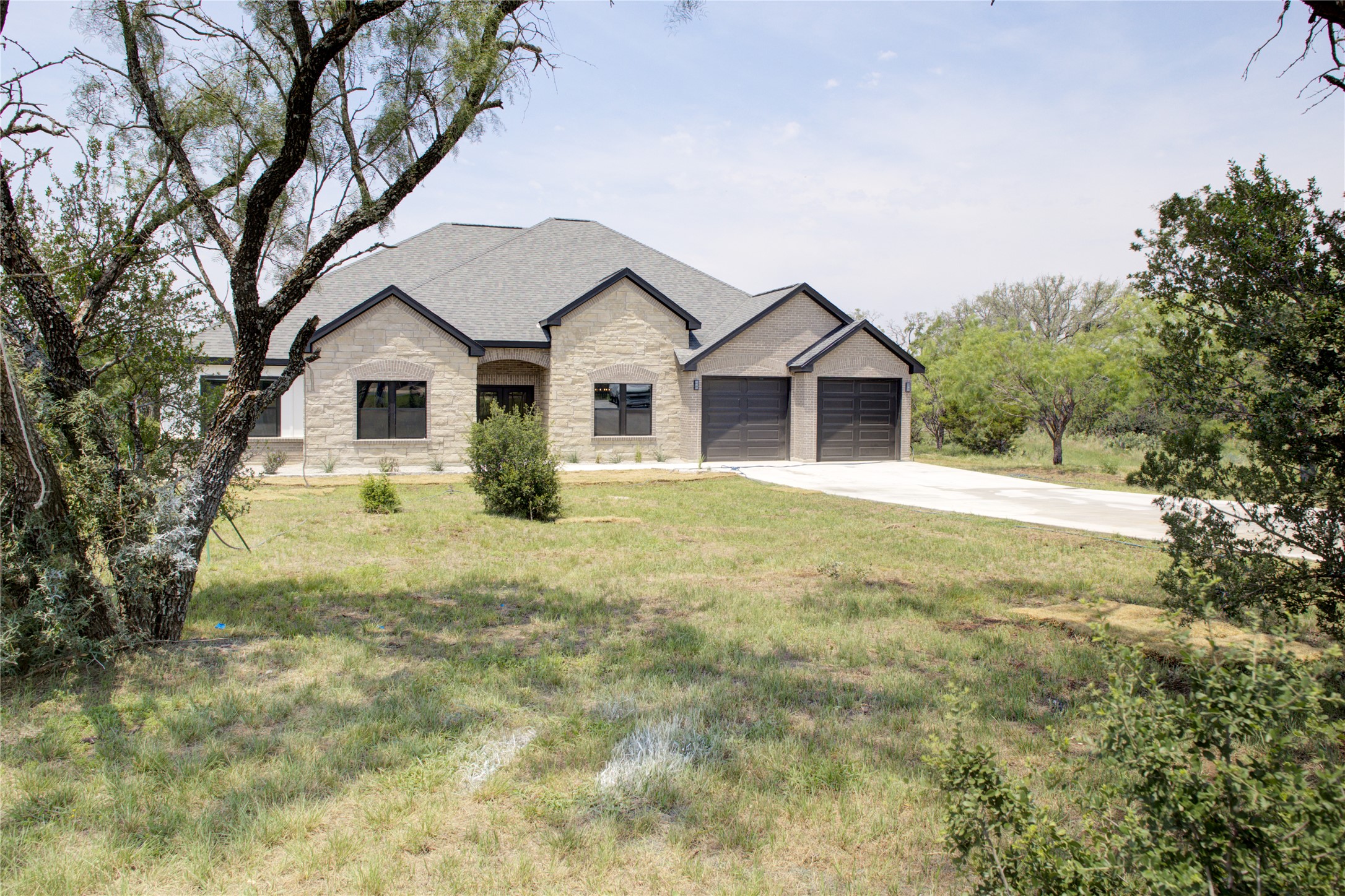 1215 Ridge Harbor Drive Spicewood, TX 78669 - Photo 2 of 39 a front view of a house with yard and green space