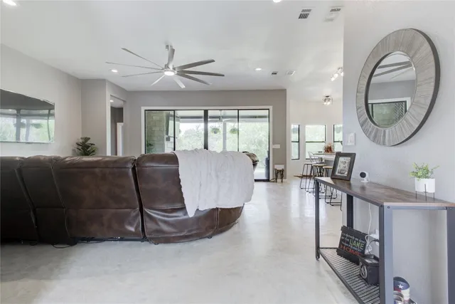 a living room with furniture a mirror and a large window
