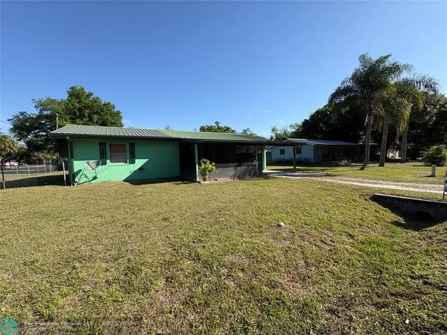 a view of a house with a yard and potted plants