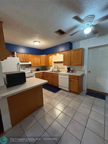 a kitchen with stainless steel appliances a stove a sink a microwave and a refrigerator