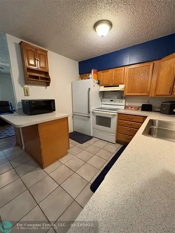 a kitchen with stainless steel appliances a stove a refrigerator a sink a stove with white cabinets