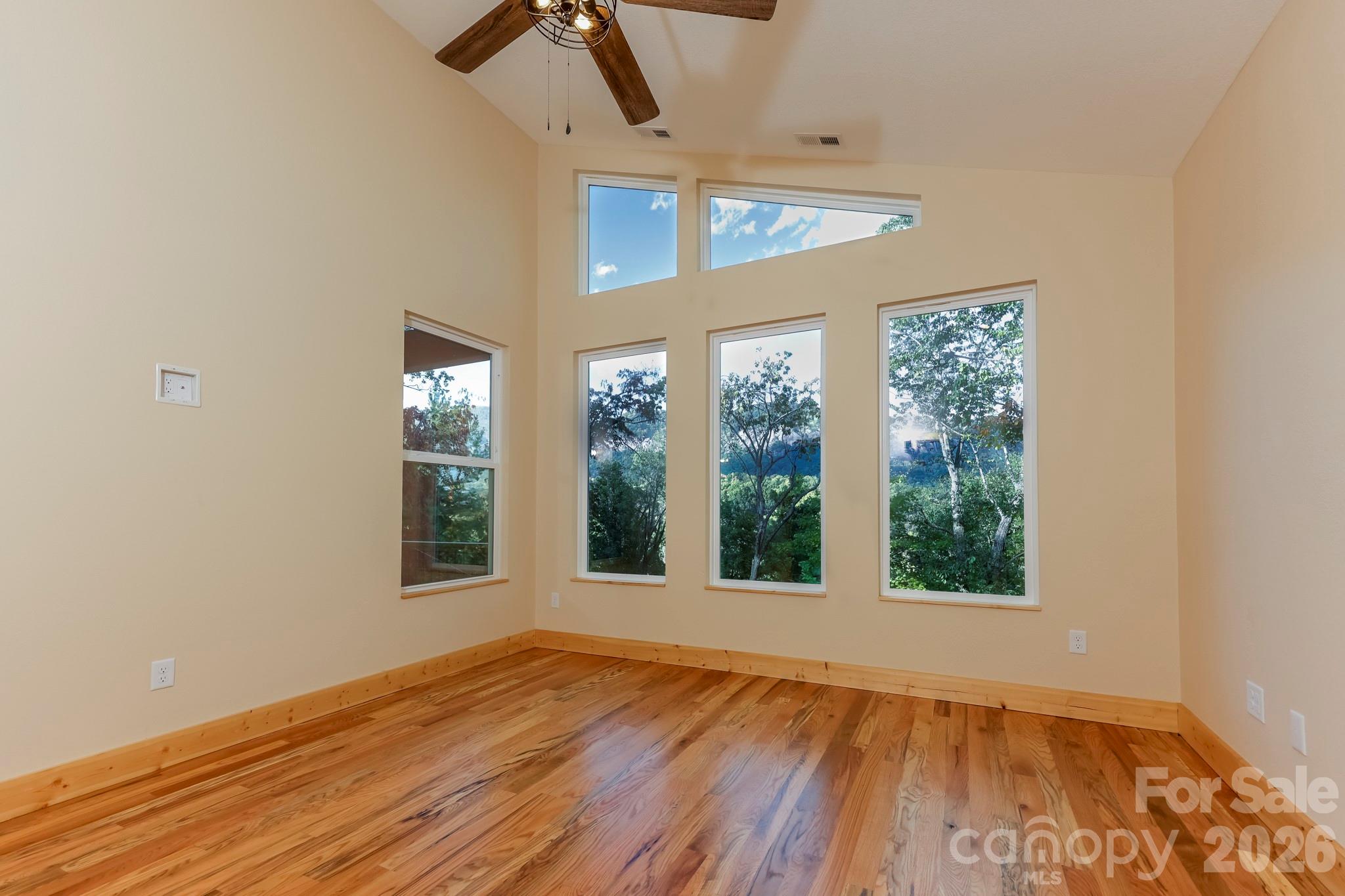 272 Seton Road Lake Lure, NC 28746 - Photo 15 of 39 an empty room with wooden floor and windows