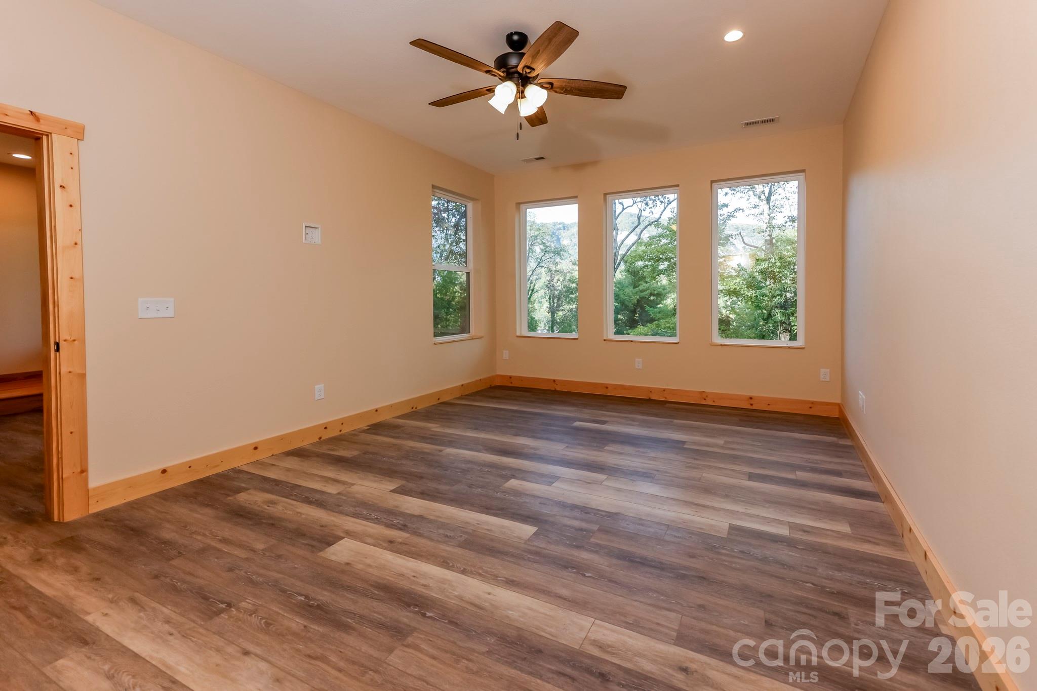 272 Seton Road Lake Lure, NC 28746 - Photo 24 of 39 an empty room with wooden floor and windows